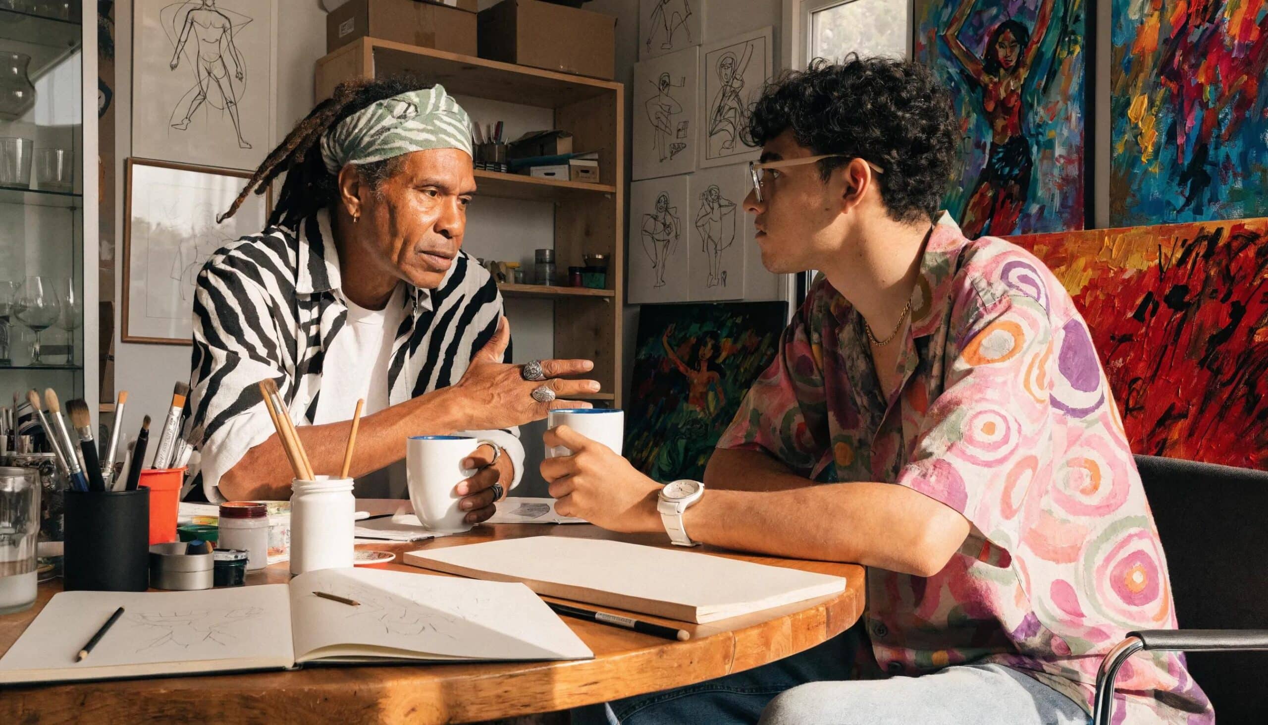 Artist Geiler Corona collaborating with a client on a custom oil painting commission in a creative workspace